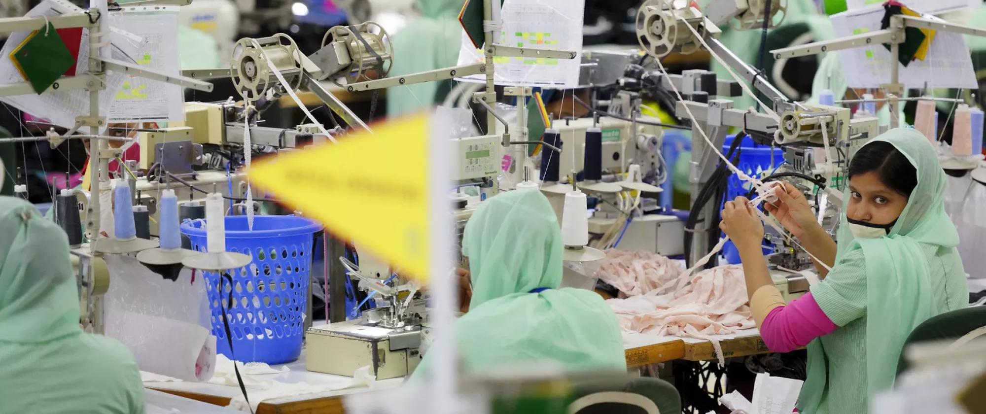 This is a photograph of a Bangladeshi woman in a ready-made garment factory in Bangladesh