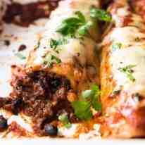 Close up of beef enchiladas in a baking dish, fresh out of the oven