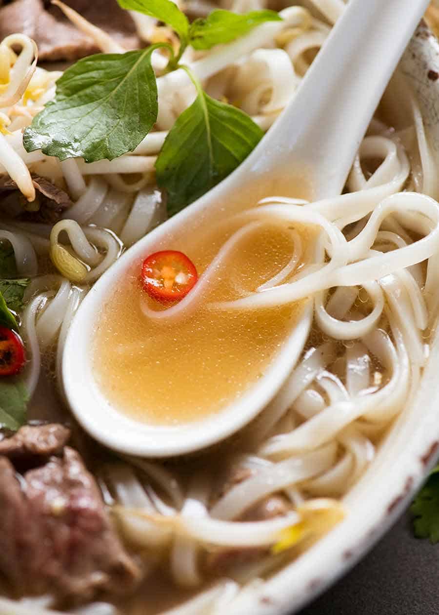 Close up of spoon scooping up Pho soup