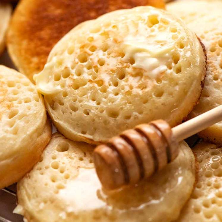 Close up of homemade crumpets with honey and butter