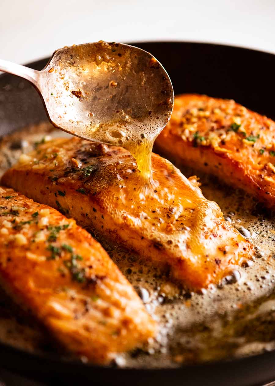Spooning foaming melted butter over Garlic Butter Salmon