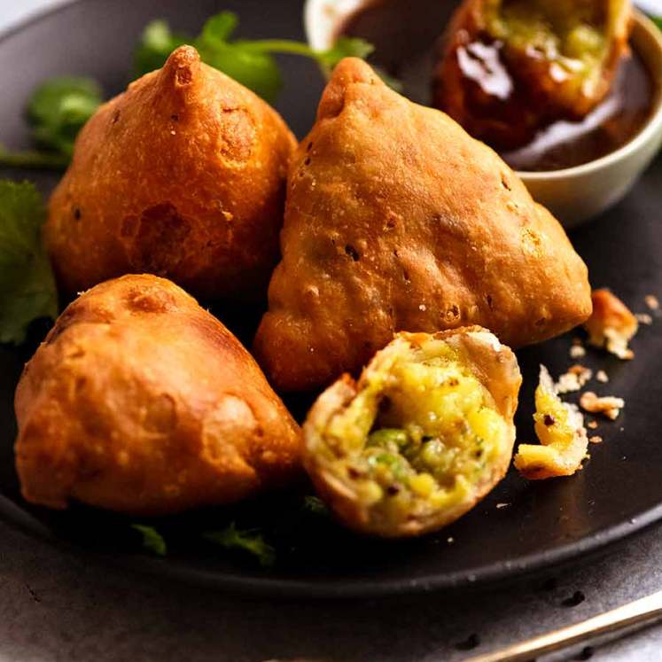 Samosas on a plate with tamarind dipping sauce