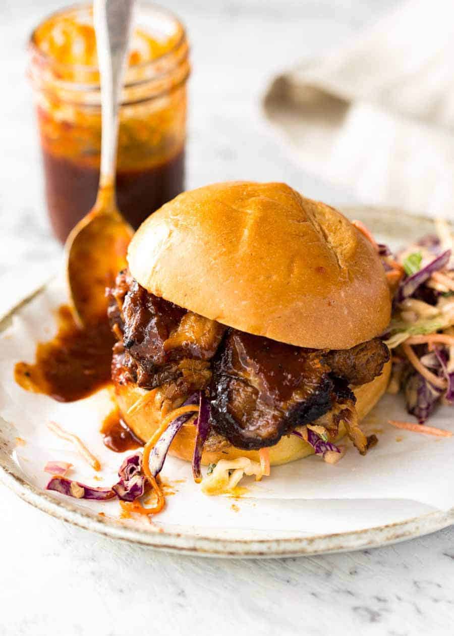 Slow Cooker Beef Brisket with BBQ Sauce on sliders on a white plate, ready to be eaten