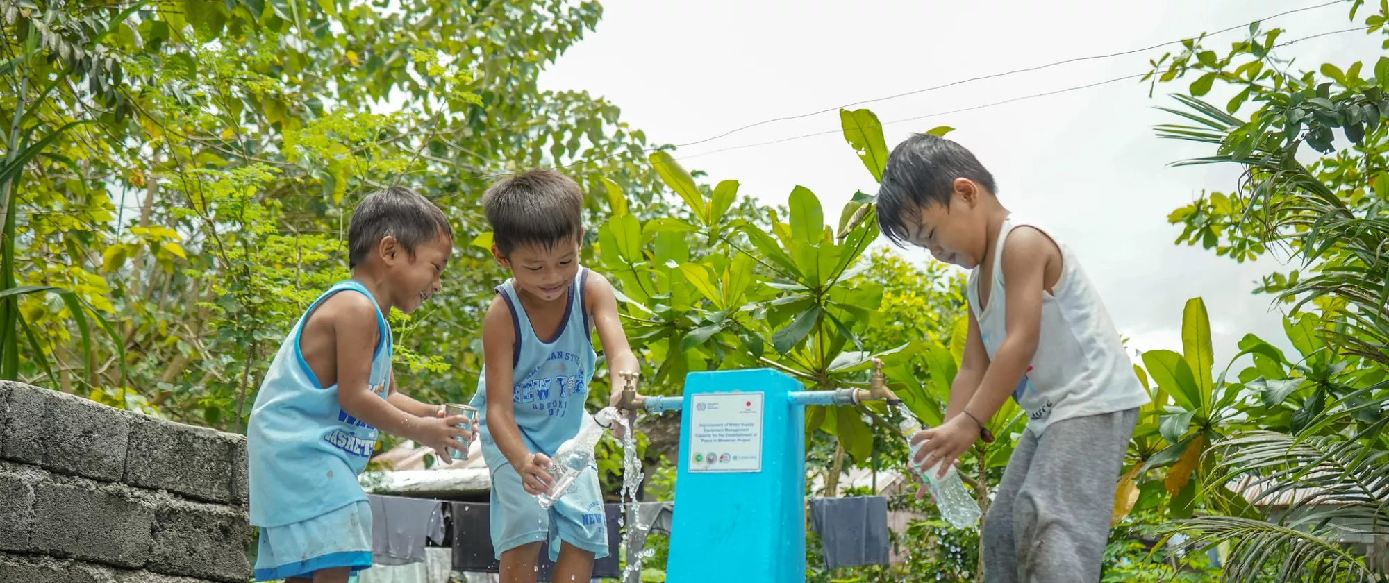 Children with water pump at a project site in the Philippines