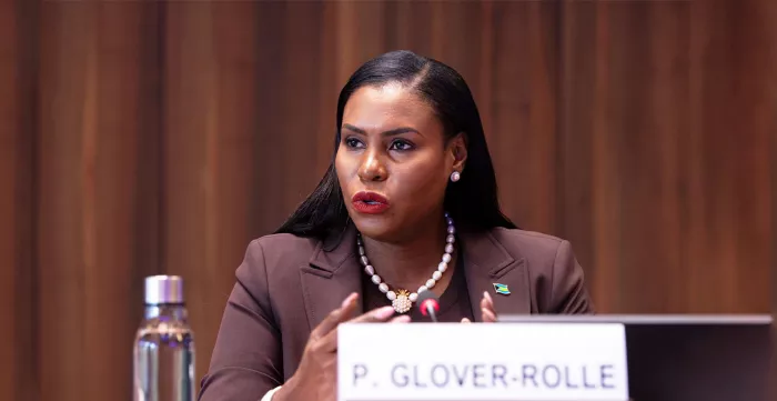 A woman sitting at a table speaking at a panel discussion