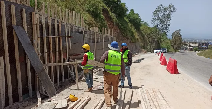 workers fixing a wall on the roas