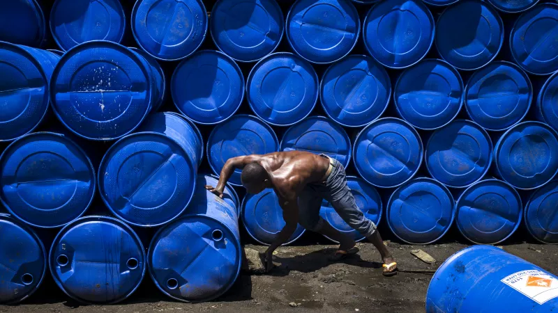 Malagasy Man pushing a Blue Barrel