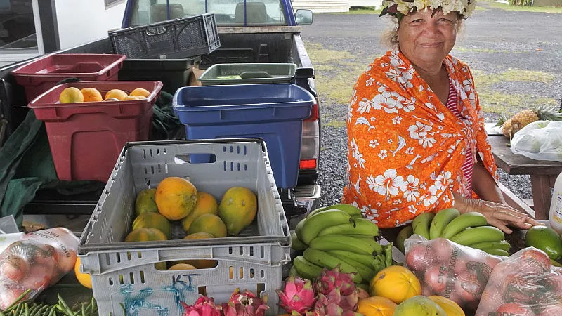 A Cook Islander woman selling fruits at Punanga Nui Market in Avarua town of Cook Islands