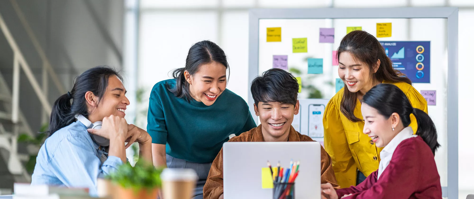 Young Asian women and men work together in a start up office