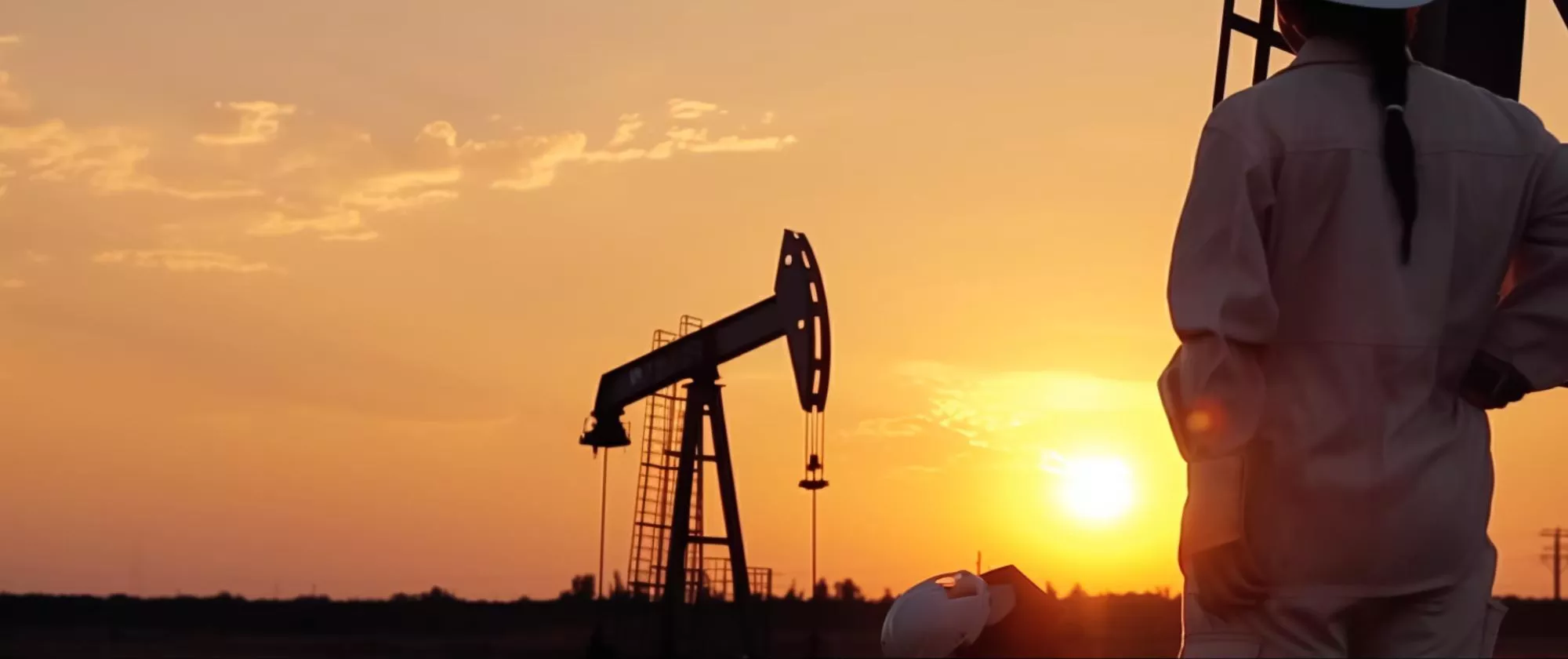 Worker and oil rig in sunset 