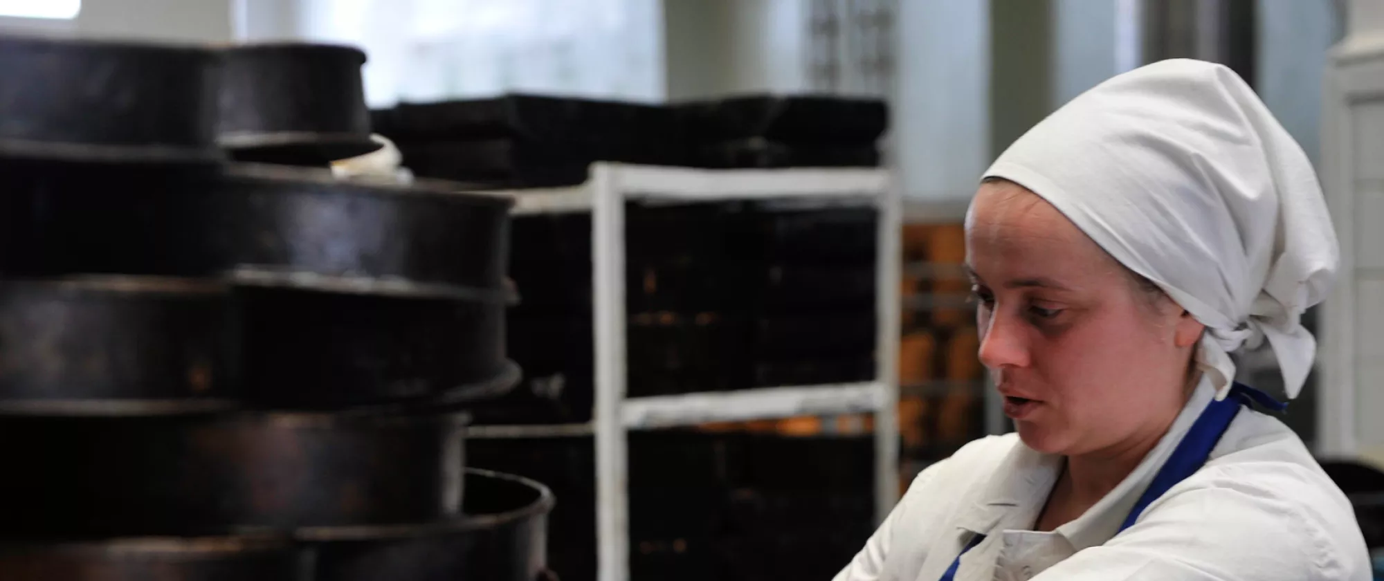 Young worker cleaning cake molds